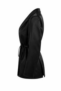 Blouse tuxedo Carolina Herrera en satin noir de la collection Été 2024, style veste croisée avec revers en pointe, nœud latéral à la taille, fermeture boutonnée dissimulée, structure de blazer avec légèreté d'une blouse, fabriquée en Italie
_vue de côté