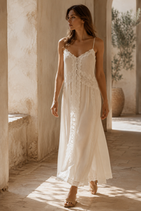 Robe maxi blanche Caroline Constas en chiffon aérien doublé, encolure ornée de dentelle délicate, corsage plissé à taille empire, jupe longue fluide et bretelles ajustables — silhouette bohème chic estivale_editoriale