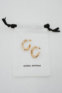 Boucles d'oreilles créoles Isabel Marant The Links en laiton plaqué or, design de maillons entrelacés, silhouette semi-ouverte contemporaine, gravure signature Isabel Marant, fermeture à tige et poussoir, fabrication italienne avec sac