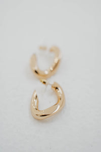 Boucles d'oreilles créoles Isabel Marant The Links en laiton plaqué or, design de maillons entrelacés, silhouette semi-ouverte contemporaine, gravure signature Isabel Marant, fermeture à tige et poussoir, fabrication italienne - détail