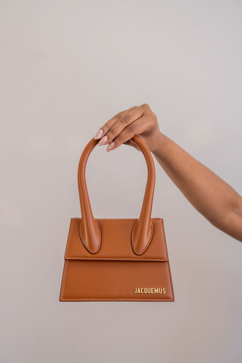 Sac à main Jacquemus Le Chiquito moyen en cuir de veau lisse brun pâle avec surpiqûres blanches contrastantes, anse roulée surdimensionnée et logo doré, maroquinerie italienne_ vue de face 2