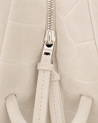 Fermeture magnétique et zip du sac Le Turismo Jacquemus ivoire, double système de fermeture sécurisé, suède croco embossé blanc cassé, logo Jacquemus en relief