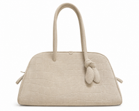 Sac bowling Le Turismo Jacquemus en suède calfskin croco embossé ivoire, anses roulées en cuir avec knotted detail caractéristique, fermeture magnétique et zip, logo Jacquemus embossé, fabriqué en Italie, taille unique