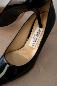 Escarpins Jimmy Choo Love 65 en cuir verni noir avec bout pointu effilé, talon stiletto 65mm, semelle cuir poli et logo métallique au talon, maroquinerie italienne
_étiquette