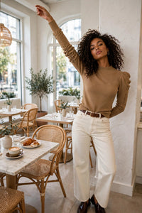 Chandail Genero Max Mara brun miel porté avec un jeans crème dans un café lumineux, pose éditoriale, vue lifestyle - PrettyInsideOut