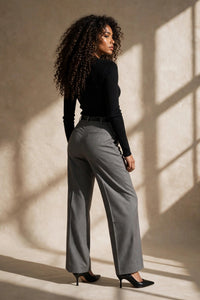 Pantalon Juanita Max Mara en laine grise chinée, taille haute, poche passepoilée au dos, porté avec un haut noir ajusté, vue éditoriale studio de dos - PrettyInsideOut