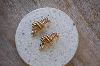 Boucles d'oreilles Rabanne en laiton doré poli miroir, motif nœud nautique sculptural, finition brillante intense, fabriquées en Italie, 1,5 x 0,75 po_closeup