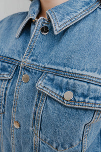 Bodysuit sans manches Carlisle par Ronny Kobo en denim moyen, boutons avant, coupe ajustée élégante - détail tissu denim
