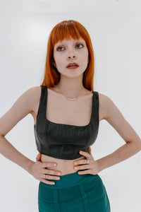 Top court Wells de Staud en faux cuir noir sans manches, style débardeur ajusté, silhouette moderne et minimaliste, finition mate - vue de face