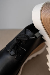 Derbys compensés Stella McCartney Elyse en similicuir grainé noir, semelle plateforme en bois de hêtre certifié FSC, bout carré anguleux, lacets, confection italienne végane_lacet