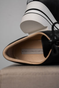Baskets compensées Stella McCartney Sneak-Elyse en microfibre végane noire, semelle plateforme micro-dentée bicolore noir et blanc, bout carré anguleux, ruban rayé signature au talon, confection italienne_intérieur