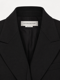 Détail des épaulettes épaisses et des poches plates à revers de la robe Victoria Beckham Black Tailored Minidress — power dressing britannique FW2024)VUE DU COL